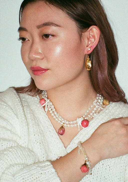 Tripled stranded freshwater and glass pearl necklace with mixed preserved rosebuds and gold clasp.