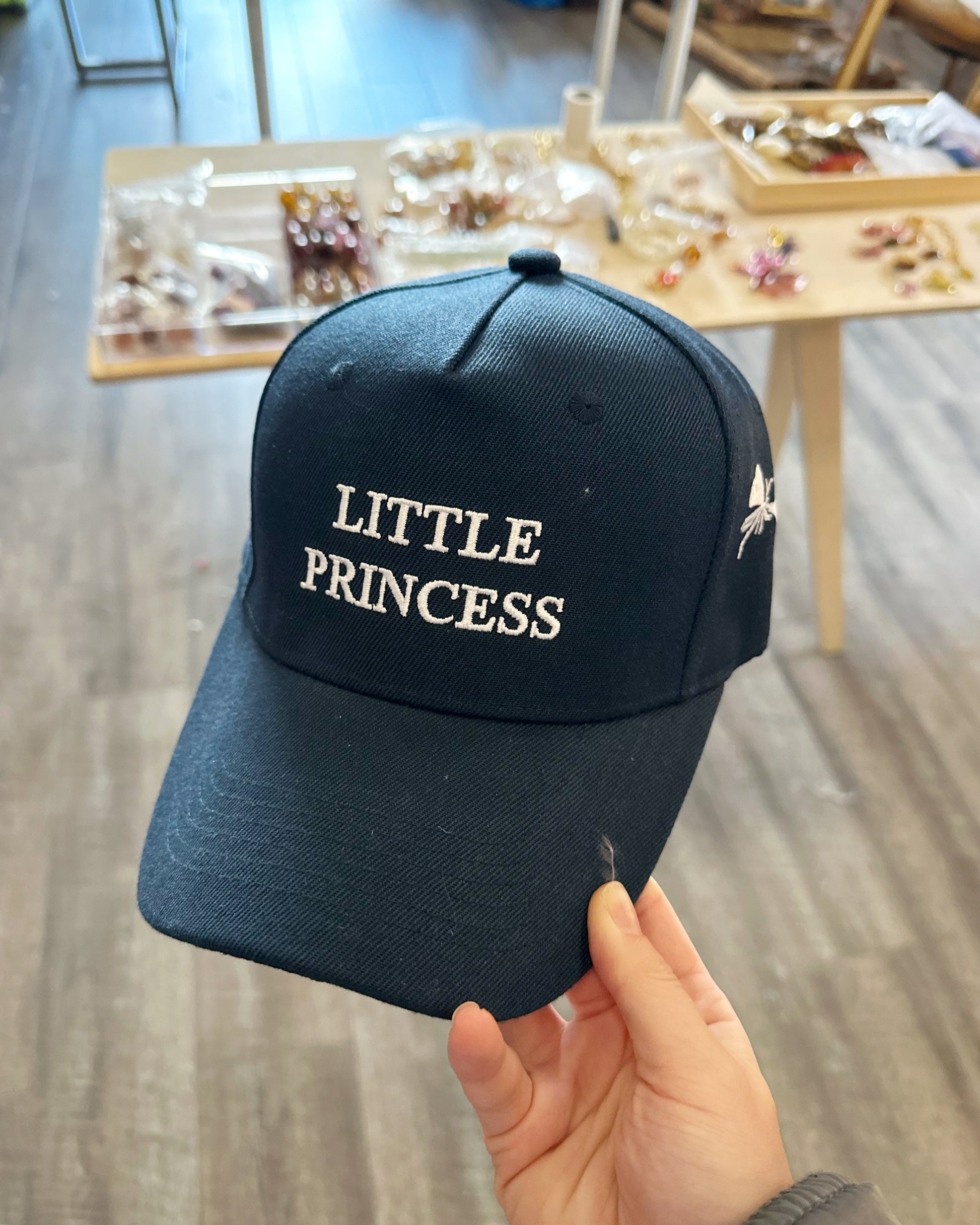 Navy blue cap with the words "Little Princess" embroidered on it in white thread.