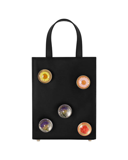 Black leather bag with 5 assorted preserved  floral knobs.