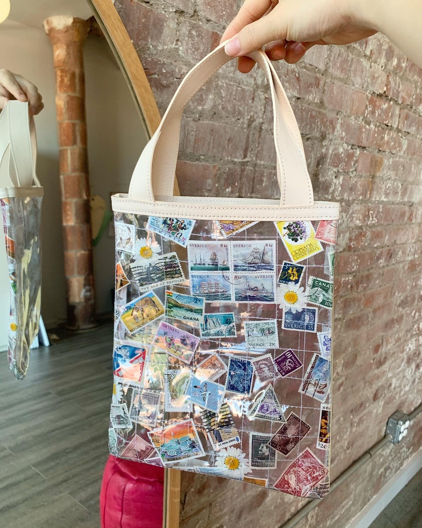 Clear quilted tote bag with stamps and daisies and cream straps.
