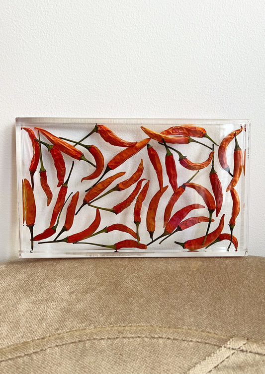 Dozens of peppers sit suspended in transparent resin. A durable-yet-whimsical addition to your home decor. Serve cocktails, use as a vanity tray, or simply display as an incredible objet d'art.