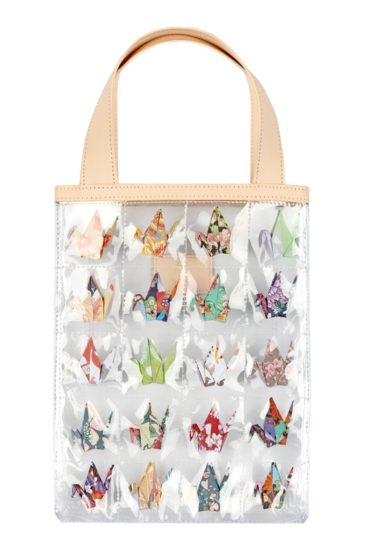 Clear quilted tote bag with mini paper cranes in each quilted square and cream straps.