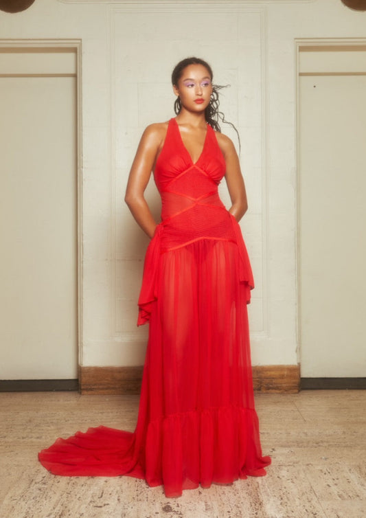Inspired by 1930s lingerie, this flowing red silk chiffon dress features a plunging neckline, hand-smocked panels, and bow details at the hip.
