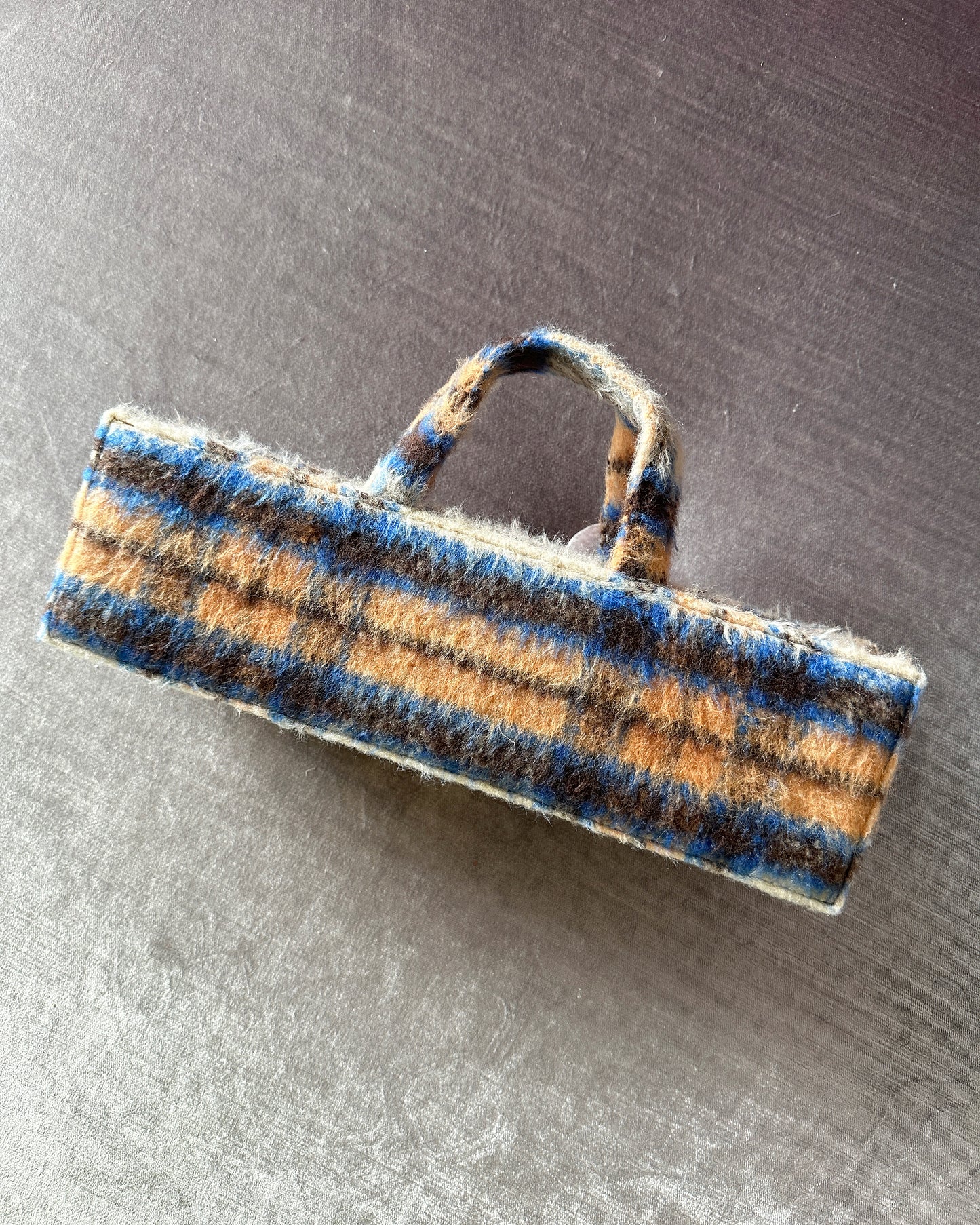 Rectangular mohair check print blue, brown, and orange bag with five assorted metal and ceramic hardware embellishments. 