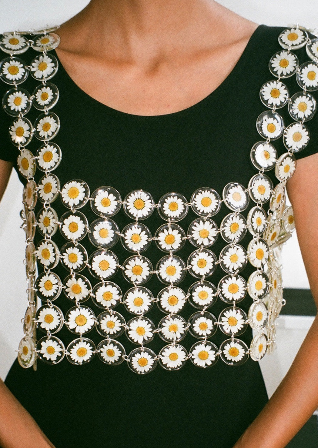 Our floral chainmaille is a distinctive technique where hundreds of preserved botanicals are intricately assembled-- this top is crafted from over two hundred daisy flowers. Relaxed fit, antiqued silver toggle side closure for easy on/off. 