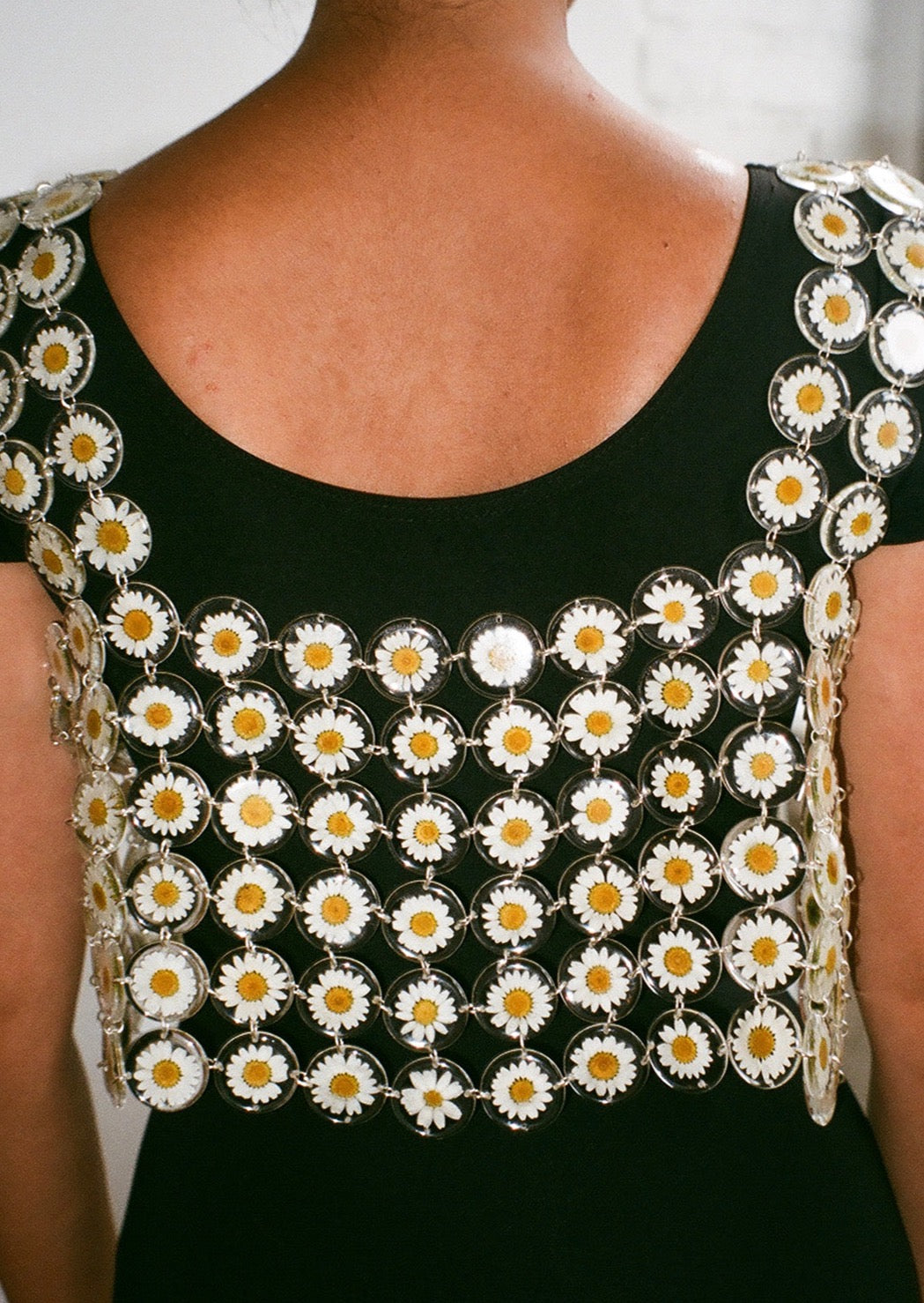 Our floral chainmaille is a distinctive technique where hundreds of preserved botanicals are intricately assembled-- this top is crafted from over two hundred daisy flowers. Relaxed fit, antiqued silver toggle side closure for easy on/off. 