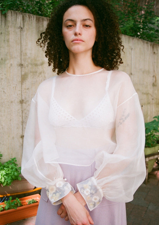 Silk organza top with voluminous bishop sleeves and an arrangement of real pressed flowers planted within each cuff. Keyhole back. Little pearl buttons.