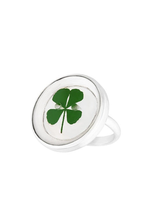 Four leaf clover in round button shaped resin on silver ring band.