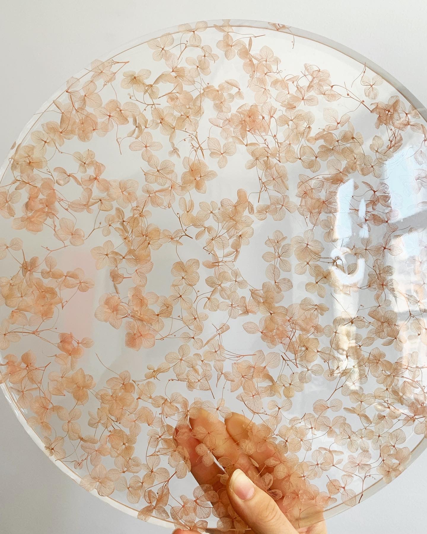 Hundreds of rosy hydrangeas sit suspended in transparent resin. A durable-yet-whimsical addition to your home decor. Serve cocktails, use as a vanity tray, or simply display as an incredible objet d'art.