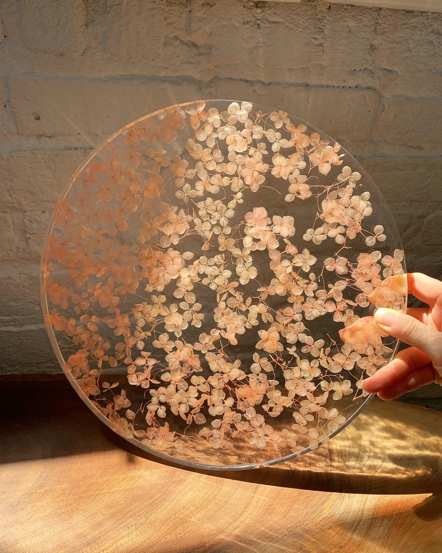 Hundreds of rosy hydrangeas sit suspended in transparent resin. A durable-yet-whimsical addition to your home decor. Serve cocktails, use as a vanity tray, or simply display as an incredible objet d'art.