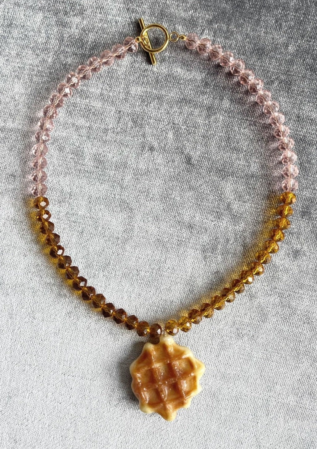 Real miniature waffle biscuit pendant preserved in resin on syrup and rose tone glass beaded chain with gold clasp.