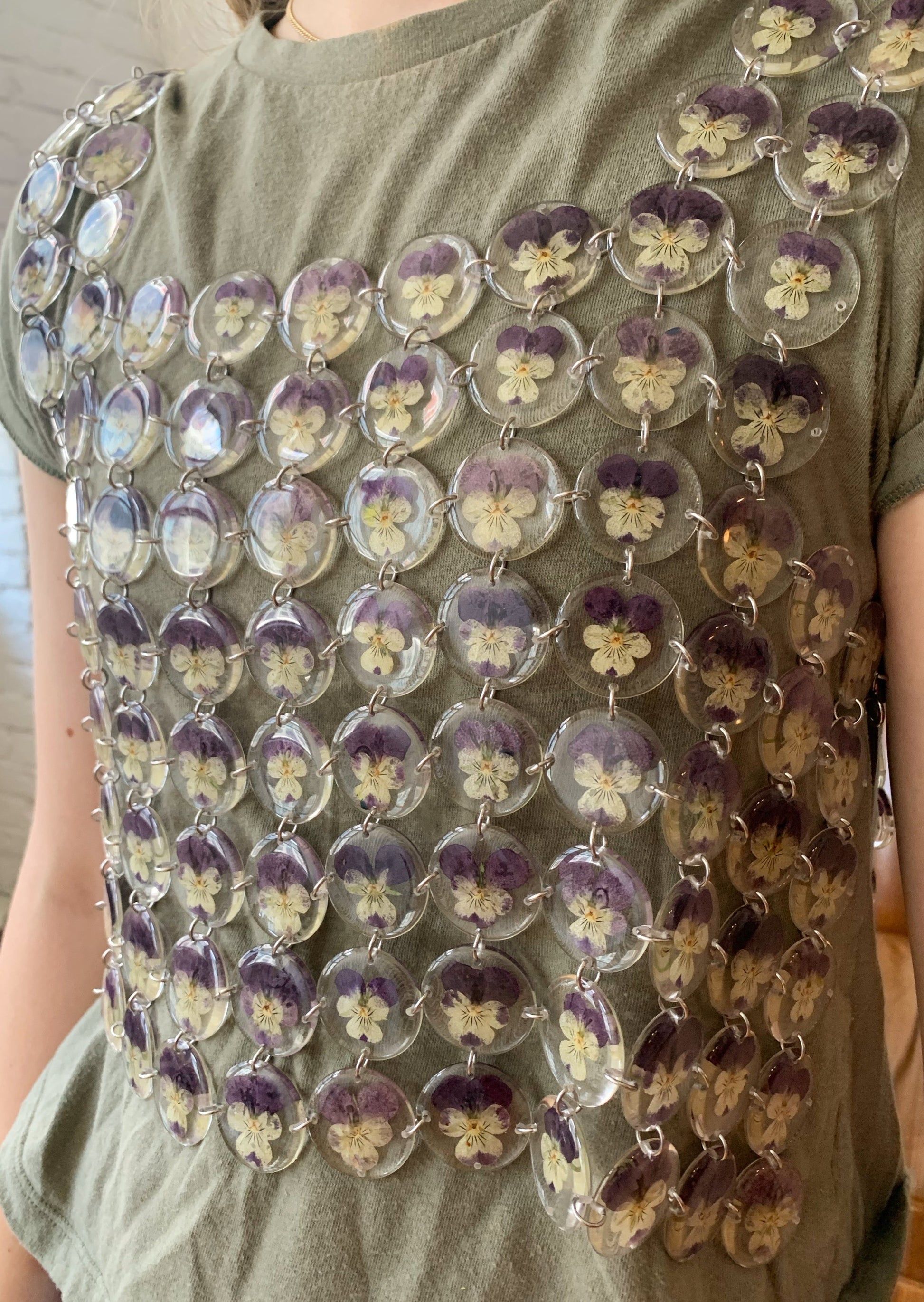Chainmaille top made of pansies preserved in round resin charms connected by silver jump rings.
