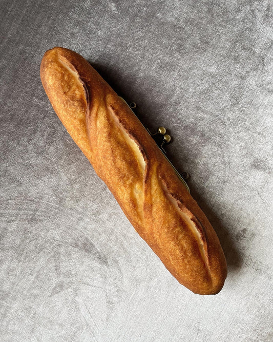 Baguette bag!  Crafted from real, surplus bread-- baked, hollowed, and reimagined into a delightful bag in Japan. Coated in an anti-bacterial and anti-fungal, eco-friendly resin.