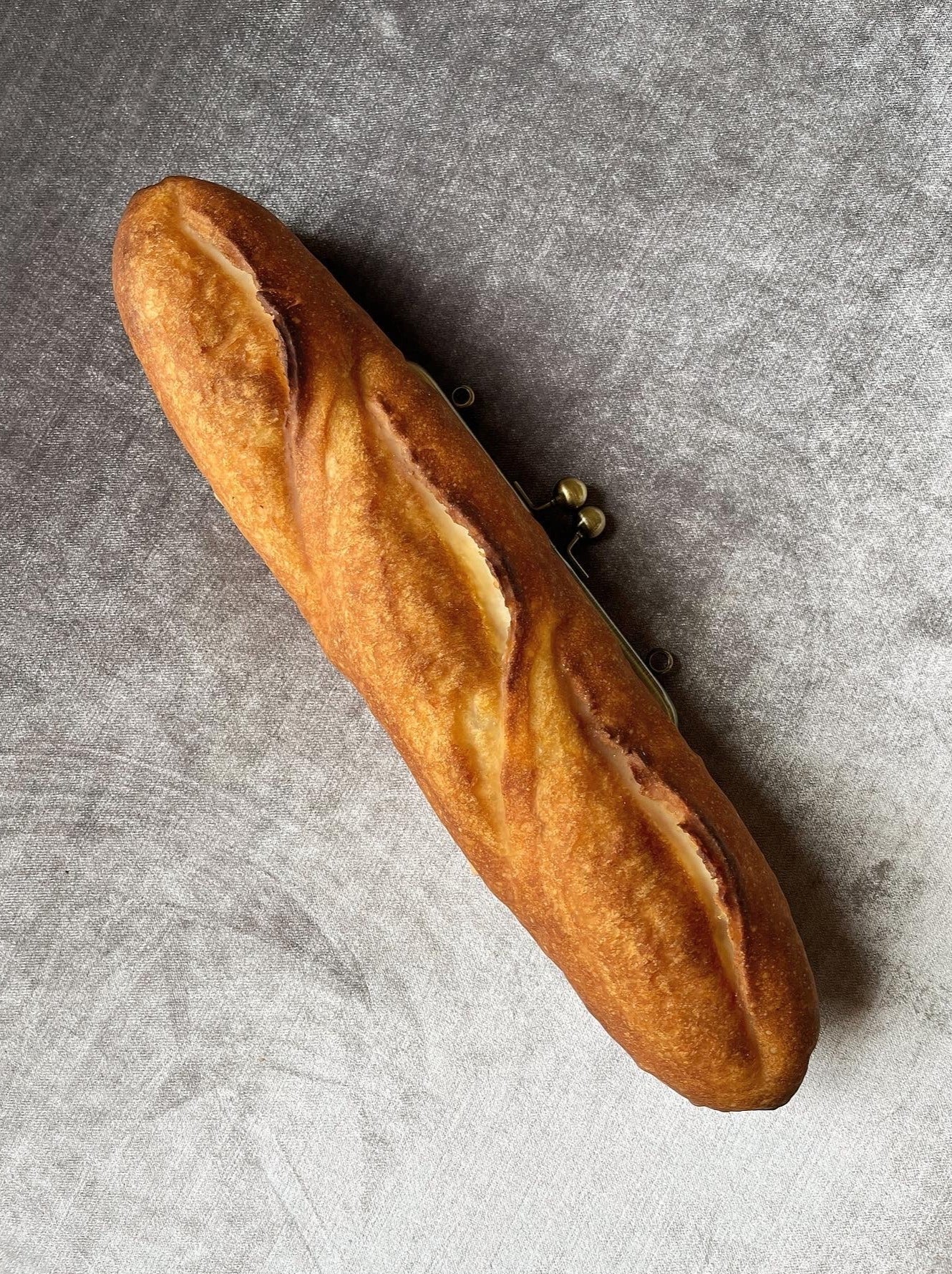 Baguette bag!  Crafted from real, surplus bread-- baked, hollowed, and reimagined into a delightful bag in Japan. Coated in an anti-bacterial and anti-fungal, eco-friendly resin.