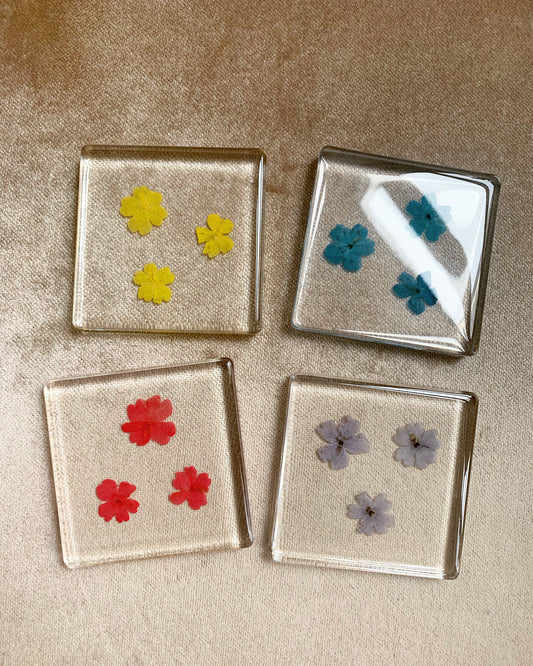 Crystal clear coasters filled with real verbena flowers. The perfect mix-and-match for your tablescape! Serve cocktails or simply display as an incredible objet d'art.  Each one unique. Approximately 3" x 3".