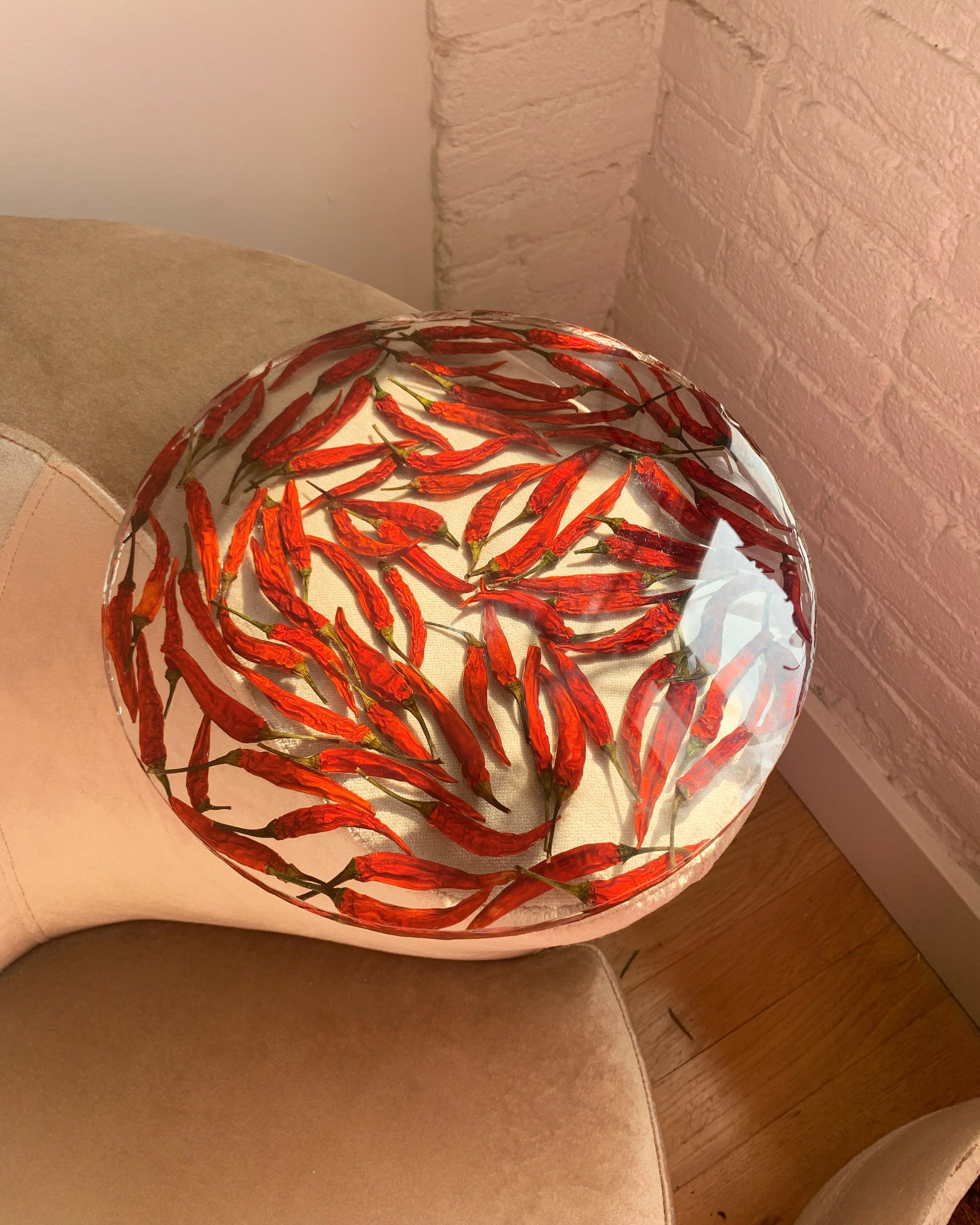 Dozens of peppers sit suspended in a round transparent resin. A durable-yet-whimsical addition to your home decor. Serve cocktails, use as a vanity tray, or simply display as an incredible objet d'art.