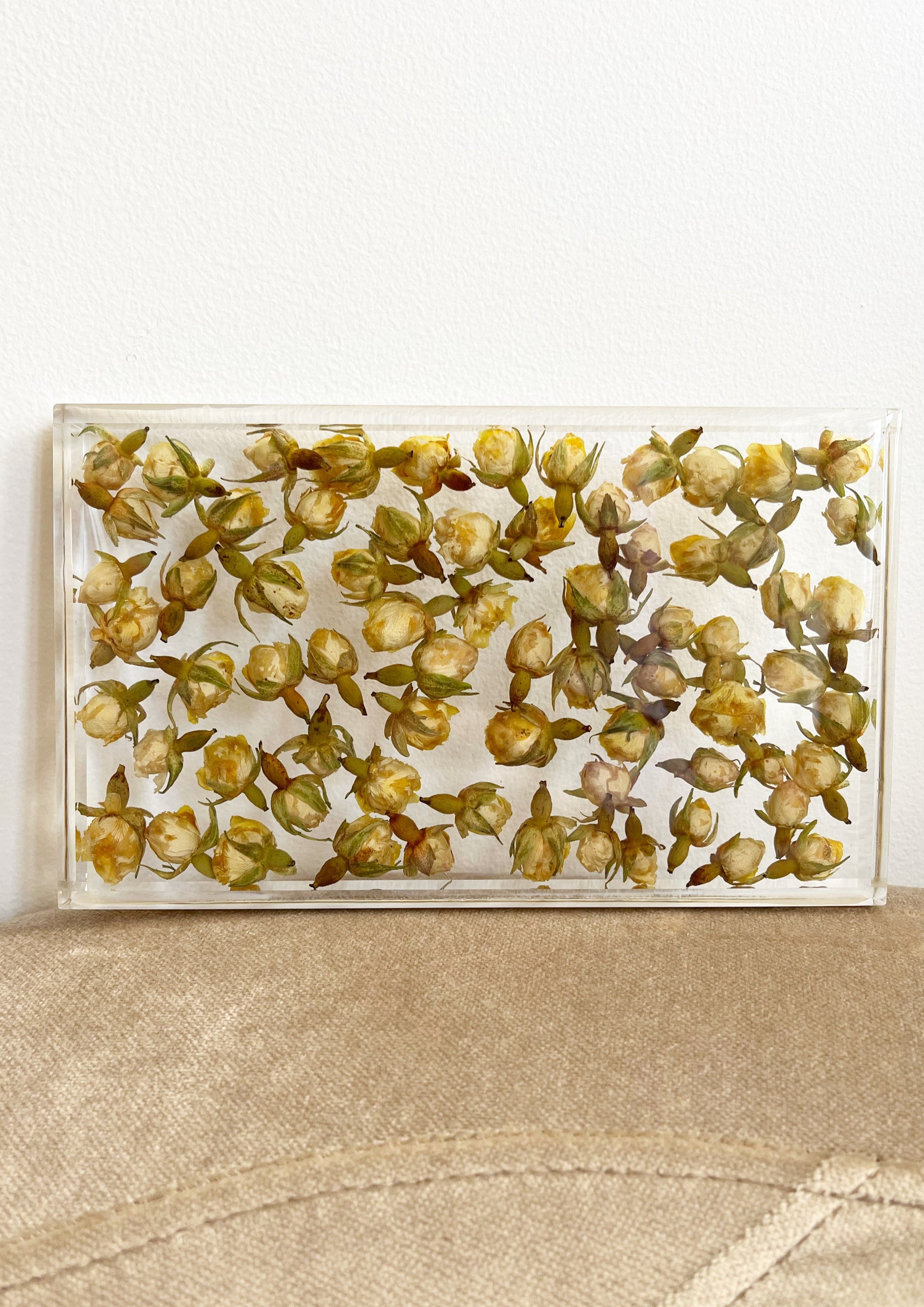 Dozens of tea roses sit suspended in transparent resin. A durable-yet-whimsical addition to your home decor. Serve cocktails, use as a vanity tray, or simply display as an incredible objet d'art.