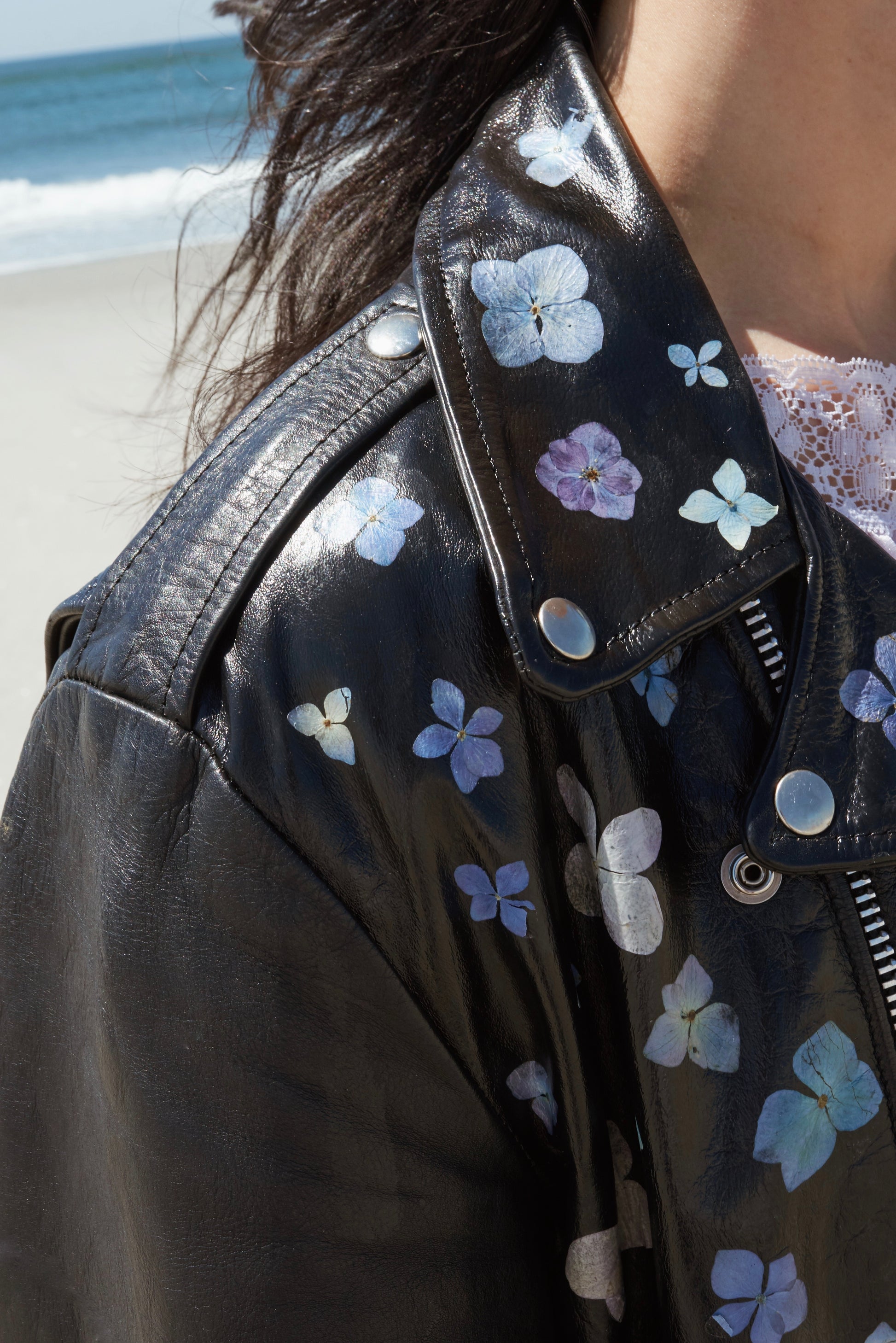 Inspired by the sidewalk gardens lining New York City each spring. This is a vintage black leather jacket coated in white paint, delicately adorned with real pressed flowers.