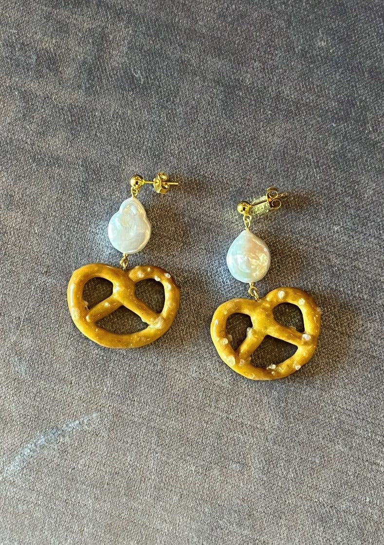 18k Gold plated .925 sterling silver studs with freshwater pearl and resin-preserved, real pretzel charm! The perfect little snack to live ear-side.