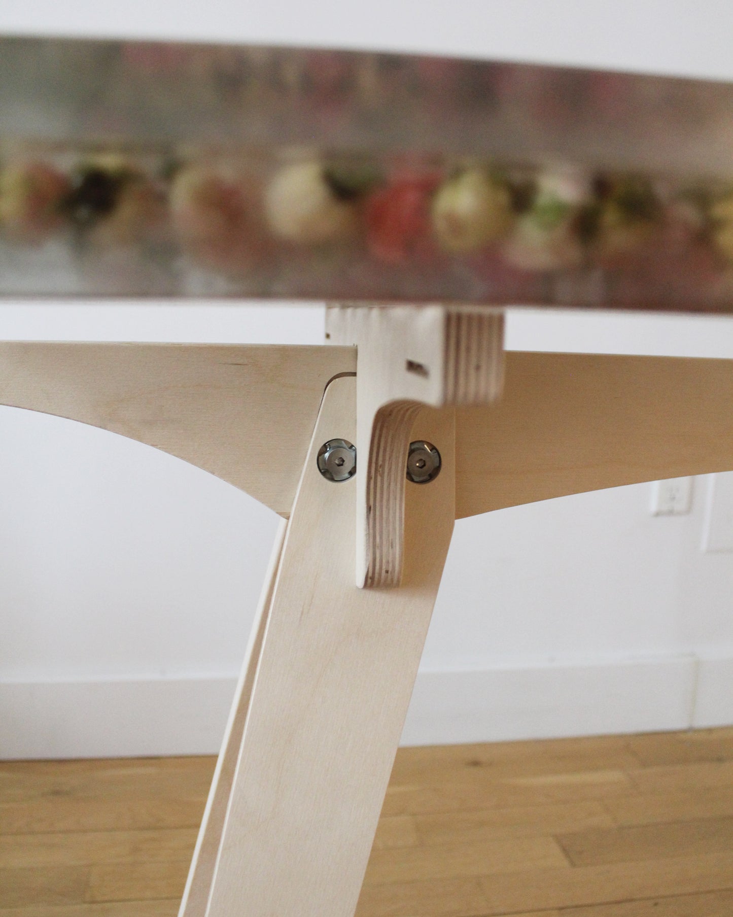 a hand-poured resin desk where hundreds of real rosebuds and baby's breath sprigs float atop a sturdy birch base