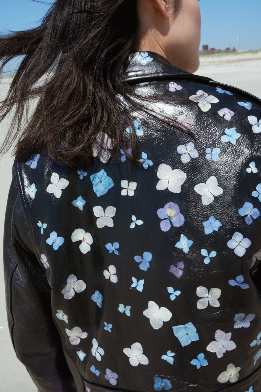 Inspired by the sidewalk gardens lining New York City each spring. This is a vintage black leather jacket coated in white paint, delicately adorned with real pressed flowers.