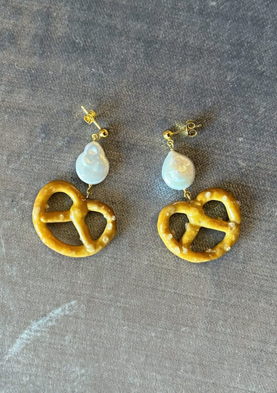 18k Gold plated .925 sterling silver studs with freshwater pearl and resin-preserved, real pretzel charm! The perfect little snack to live ear-side.