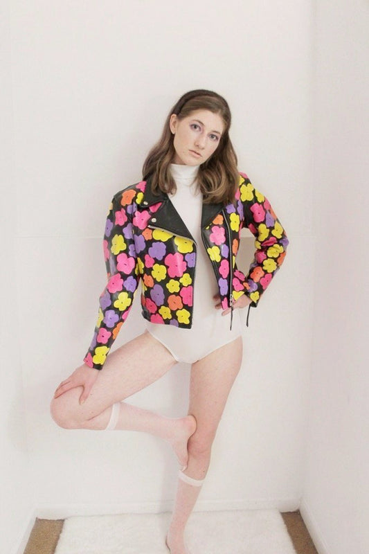 Black leather jacket hand-painted with pink, orange, and yellow 80s florals inspired by Andy Warhol's iconic pop art.