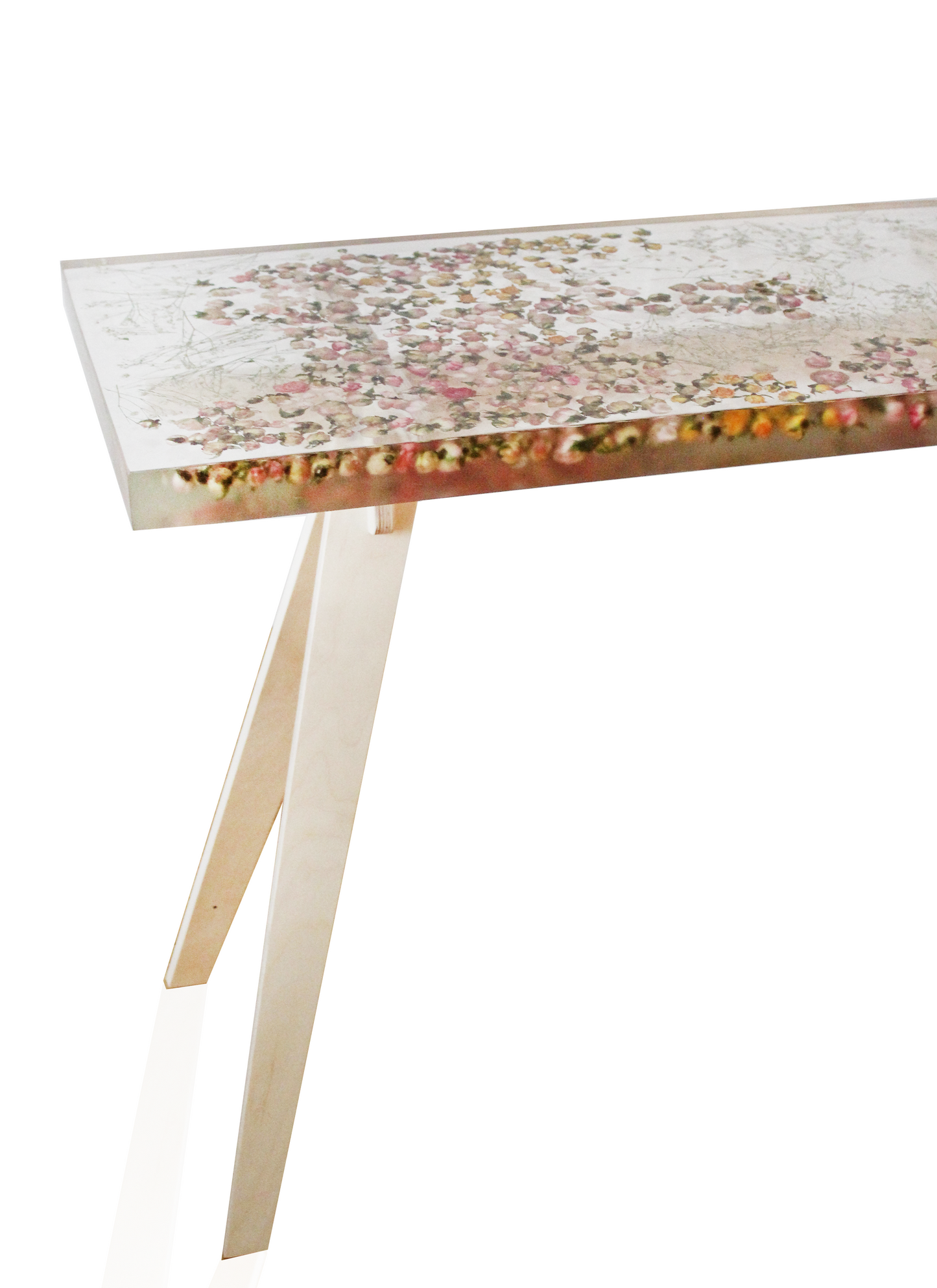 a hand-poured resin desk where hundreds of real rosebuds and baby's breath sprigs float atop a sturdy birch base