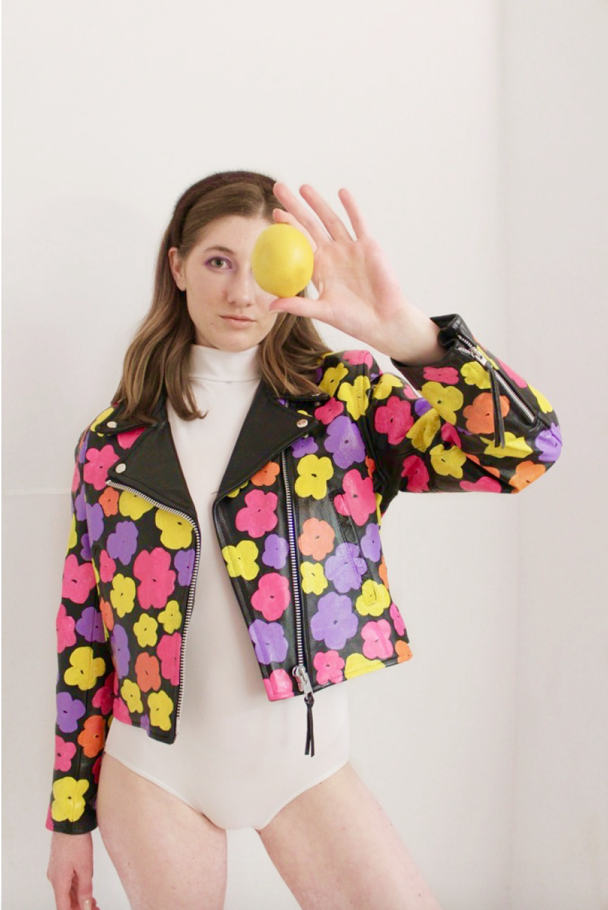 Black leather jacket hand-painted with pink, orange, and yellow 80s florals inspired by Andy Warhol's iconic pop art.