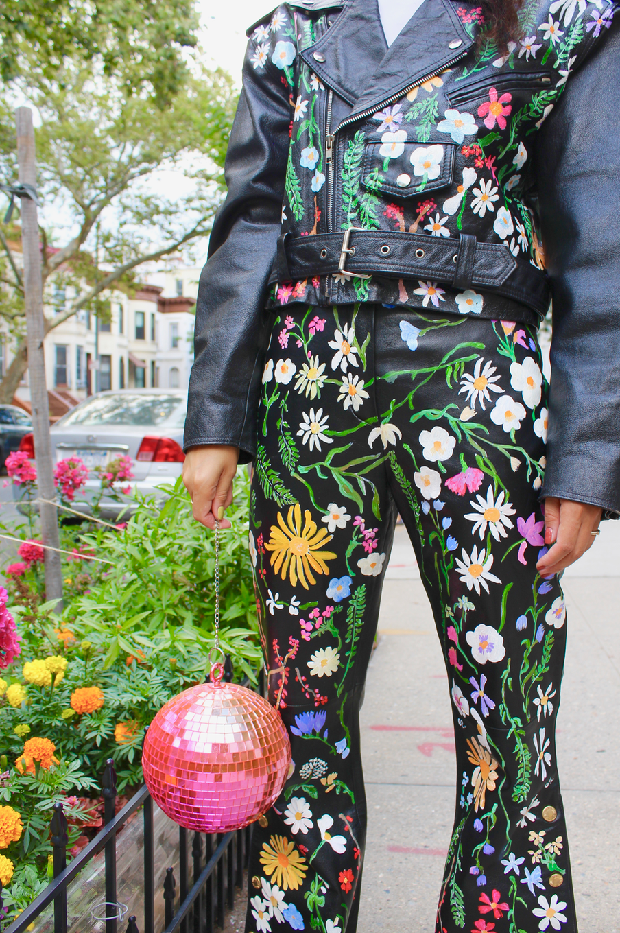 Fully hand-painted black motorcycle jacket dating from the 1980s. Floral scrapbook imagery to front, inspired by vintage pressed botanical prints. Pearl powder infused, crane-painted backside, modeled after antique mother-of-pearl inlaid cabinetry.  Cropped style with silver hardware and adjustable belt