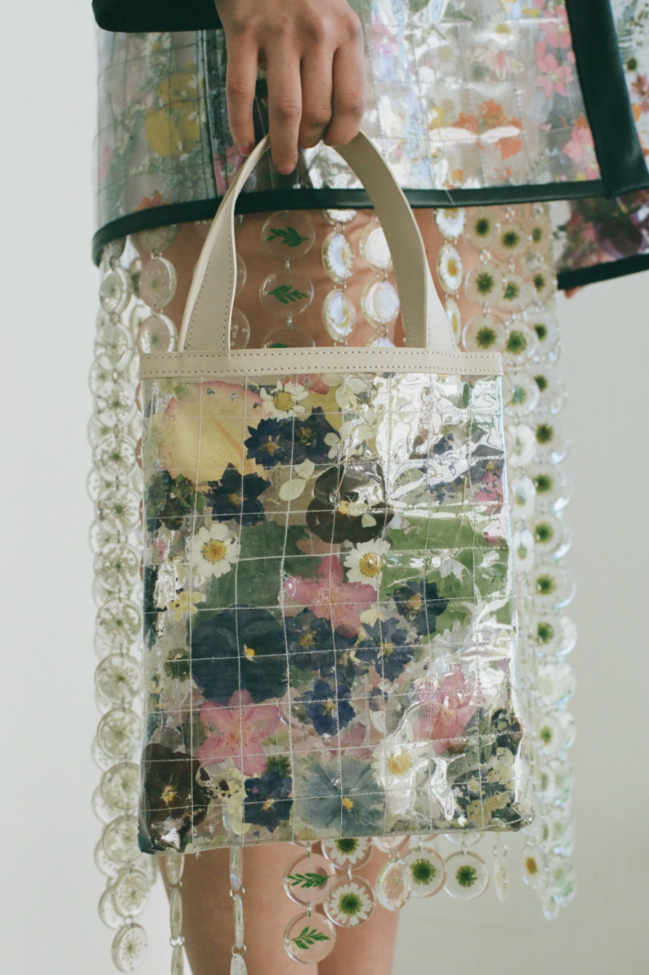 Clear quilted tote bag with dried leaves and flowers and cream straps.