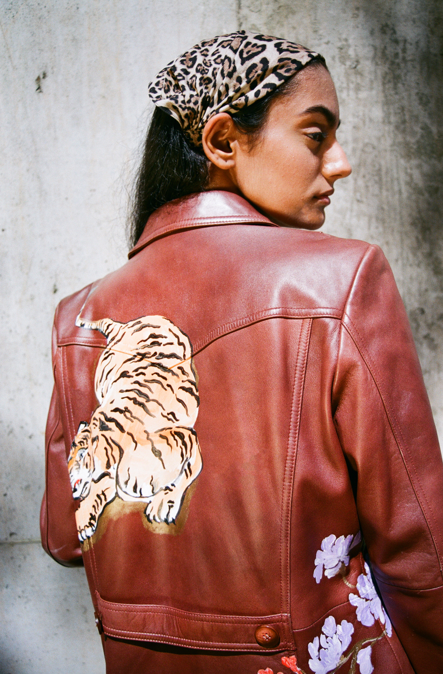 Hand-painted brown leather sportswear jacket from the 1980s.  Tiger and floral motifs adapted from Chinese scroll paintings and cabinetry.