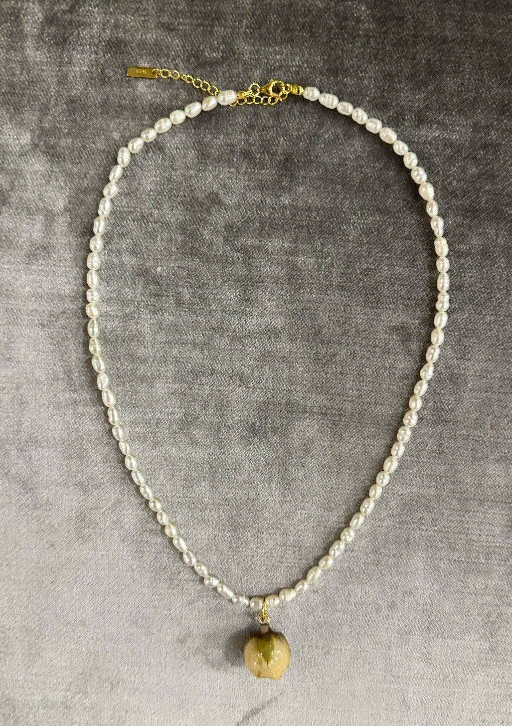 Freshwater rice pearl necklace with preserved rosebud pendant.